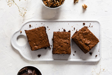 Chocolate brownie cake, dessert with nuts on dark background, directly above, copy space