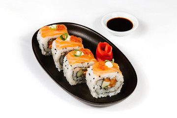 The concept of Japanese and Chinese cuisine. Sushi rolls laid out on a plate and soy sauce.