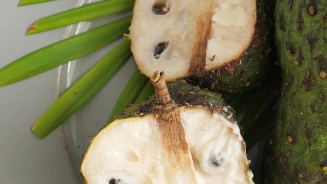 Closeup of green soursop graviola, exotic, fruit Guanabana on plate, Rotate