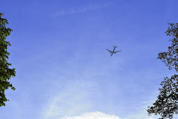 Airplane in the blue sky and cloud.The passenger plane on a background of the dark blue sky.