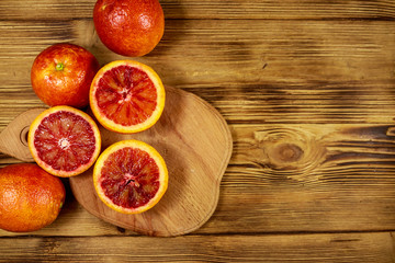 Red blood oranges on wooden table. Top view