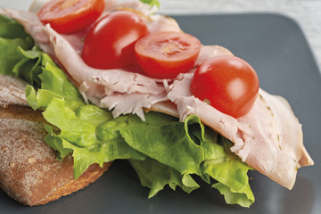 pane e prosciutto con insalata verde e pomodori da sopra primo piano