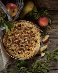 Apple pie in copper form. Apples and field flowers in old basket. Rustic style 
