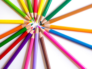 Fototapeta premium Colour pencils in circle form on white paper background as a background.