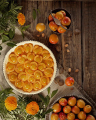 Raw apricot pie before baking. Apricots and marigolds on wooden background
