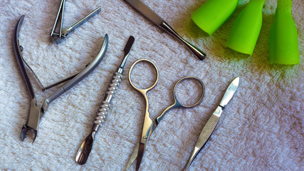 Equipment for beauty shop,cosmetic salon or beauty parlour.Manicure tools in the beauty salon.Equipment for manicure or pedicure salon.Scissors,pliers,tweezers, blade and nail the clamps on the table. - obrazy, fototapety, plakaty