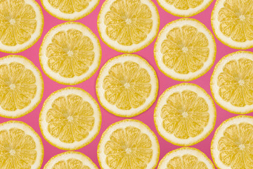 Pattern made from fresh lemon slices on a pink background, overhead view, flatlay. Fruit background.