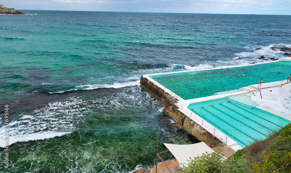 Wall mural sydney - november 6, 2015: beautiful view of bondi beach iceberg pools on a cloudy day. sydney attra