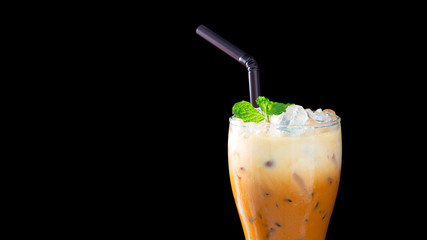 A Glass of Thai iced milk tea with mint leave.