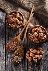 Food ingredients in wooden spoon on wooden background. Flax, pumpkin seed, sunflower and sesame.