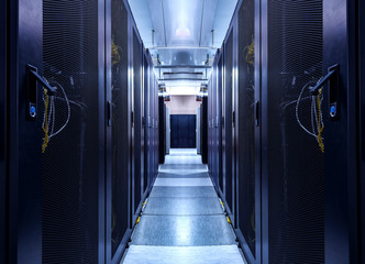 Shot of Corridor in Working Data Center Full of Rack Servers and Supercomputers. concept of big data storage and cloud computing technology.
