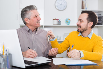 Mature man and agent sign rental agreement