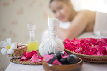 Obraz na płótnie Canvas Spa concept: zen stones, candles and flowers on the background of woman receiving treatment