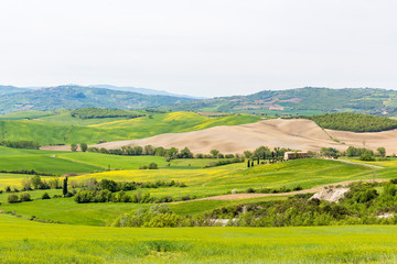 Fototapeta na wymiar Italian farm on a hill with fields in a rural landscape
