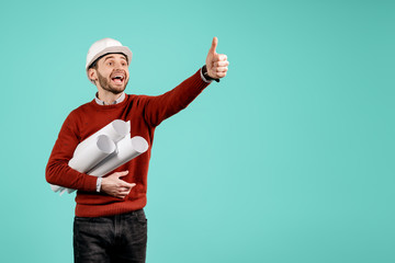 Attractive young handsome bearded engineer or constructor man in casual outfit show ok gesture over cyan background. Architecture and Renovation concept.