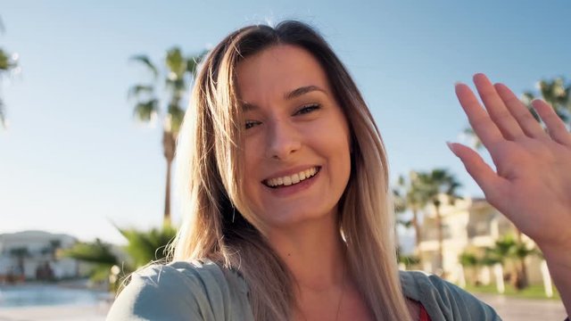 Beautiful woman having video chat using smartphone outdoors sharing travel adventure with friends. Girl filming selfie video for social media, having video chat, sharing experience using phone.