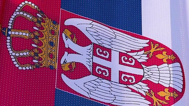 Closeup shot of a brightly illuminated Serbian flag waving in wind