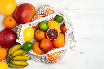 Organic citrus fruits variety in cotton mesh reusable shopping bag - recycling, sustainable...