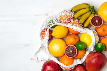 Organic citrus fruits variety in cotton mesh reusable shopping bag - recycling, sustainable lifestyle, zero waste, no plastic
