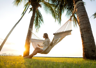 girl in a hammock bother palm trees enjoying a tropical vacation