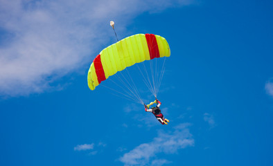 skydiver with parachute in the blue sky