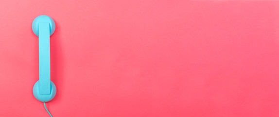 Retro phone on a pink paper background