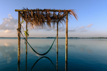 wooden construction with a hammock in a lake called Laguna Milagros at sunset, Chetumal, Mexico © Stefan