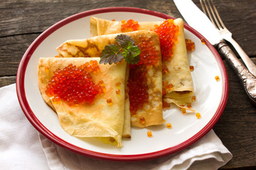 Tasty crepes with caviar. French crepes, russian or ukrainian on white background. Maslenitsa holiday food