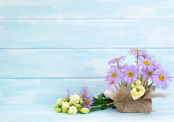 Chamomile and rose flowers on wooden wall background in Shabby Chic style. Empty place for your text.