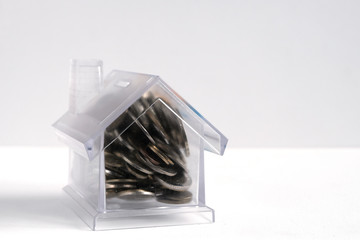 House-piggy. Transparent plastic house on a white background. Business financing concept. Copy space.