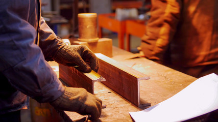 Construction plant. A man working with a small iron detail