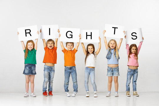 All people have rights. Group of happy smiling and screaming children with a white banners making word isolated in studio background. Education, advertising and social right concept.