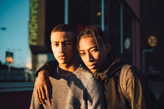 Portrait of teenage friends standing in city at sunset