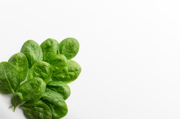Young green spinach leaves on a white background. Clean food, detox, diet food ingredient - green organic spinach.