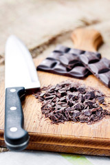 Chopped dark chocolate on wooden cutting board