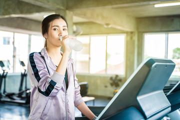 Fitness asian running women drinkink water after run on treadmill