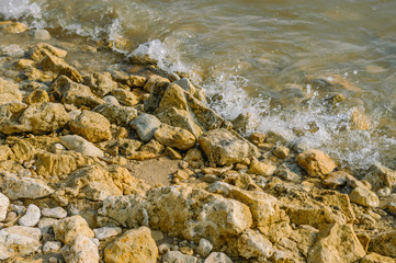 Sea, wave, yellow-brown stones. Nature.