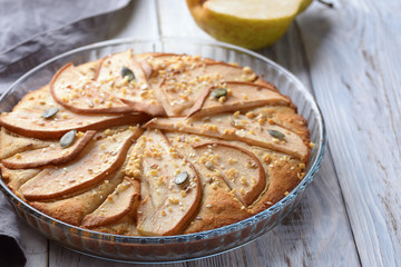 gorgeous pie with pears in a glass container on wooden background