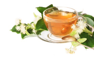 Linden tea on a white table in a glass cup. Flower tea, herbal medicine
