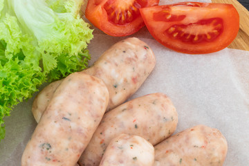 Fresh raw sausage on the wooden background, top view
