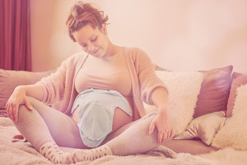 Obraz premium Beautiful pregnant woman touching her belly and enjoying at home.