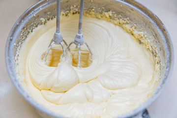 Cooking cupcakes at home. The dough is mixed with a mixer in a saucepan