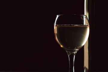 wine bottle and wine glass in a black background