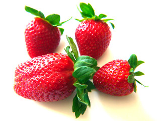 Red strawberries with green leaves isolated on white background.