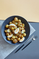 Cooked poatoes with eggs on a geometric shaped background
