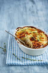 Potato gratin on a blue wooden surface