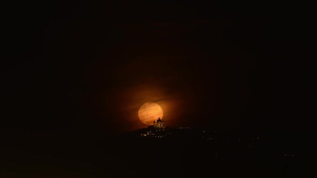 Super Luna cresce dalla collina alle spalle della basilica di Superga 