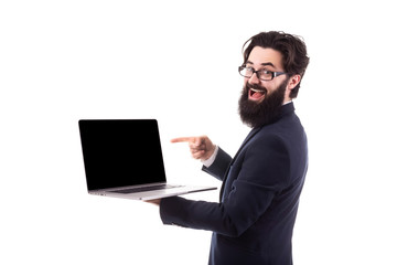 smiling bearded businessman showing blank laptop computer screen and pointing on it while, isolated on white background