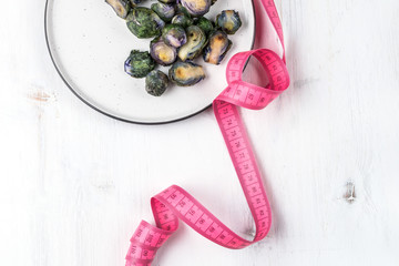 Healthy food concept, dieting, vegetarian, vegan - organic purple brussel sprouts fried on plate with lemon, top view