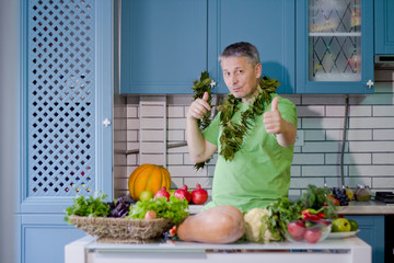 A man in the kitchen prepares vegetarian dishes. Vegetables , ready for cooking.